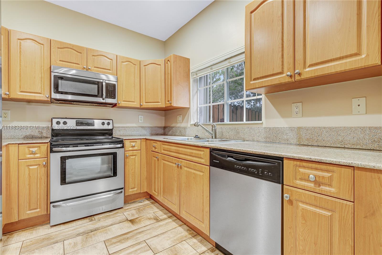 7627 East Stonecreek Circle Davie, FL 33024 - Photo 6 of 29 a kitchen with stainless steel appliances granite countertop a sink stove and microwave