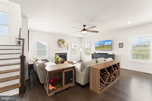 a living room with stainless steel appliances kitchen island granite countertop furniture and a dining table with wooden floor