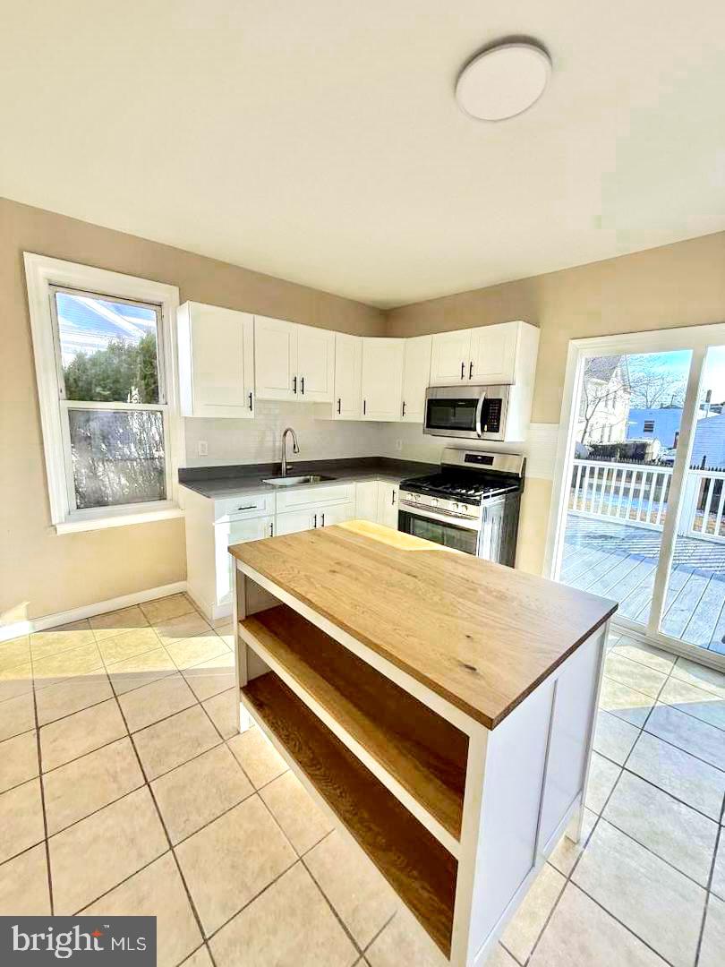 136 Webster Street Riverside, NJ 08075 - Photo 2 of 4 a kitchen with stainless steel appliances a stove a sink and a microwave