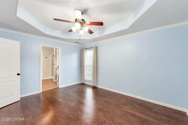 a view of an empty room with wooden floor
