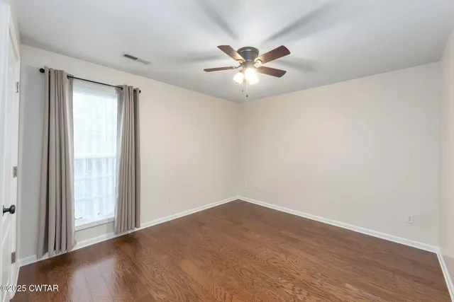 a view of a big room with wooden floor closet and windows