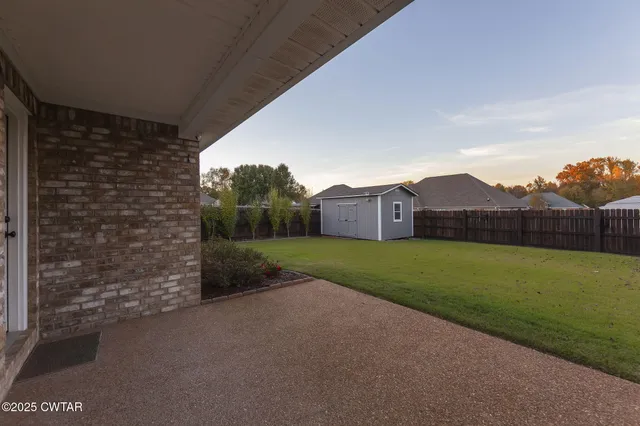 a view of a house with a yard and wooden fence