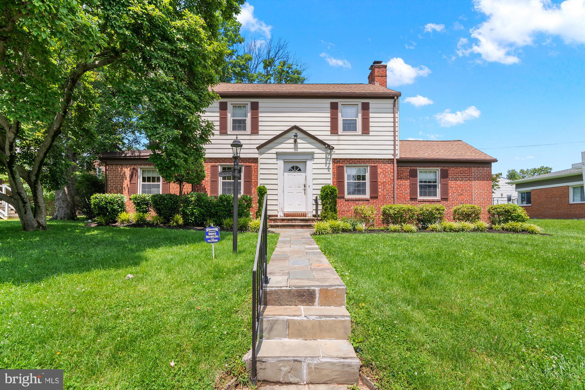 a front view of a house with a yard and trees