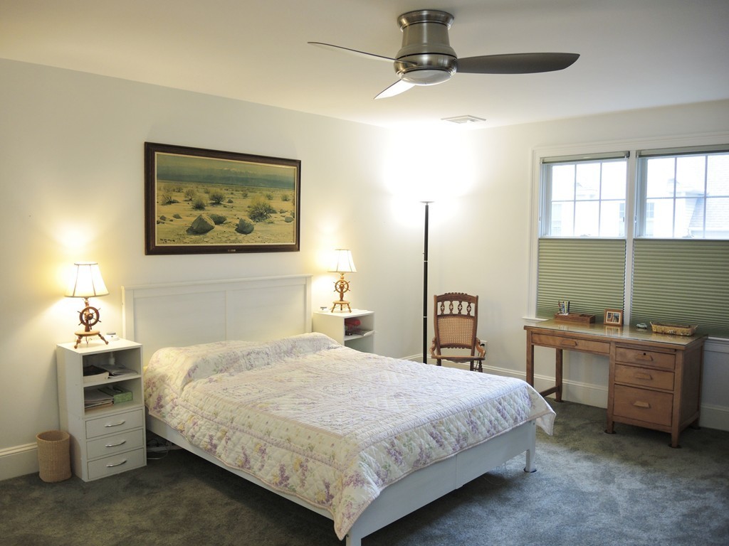 38 Maple Street, Unit 2 Needham, MA 02492 - Photo 19 of 26 a bedroom with a bed and a table in it