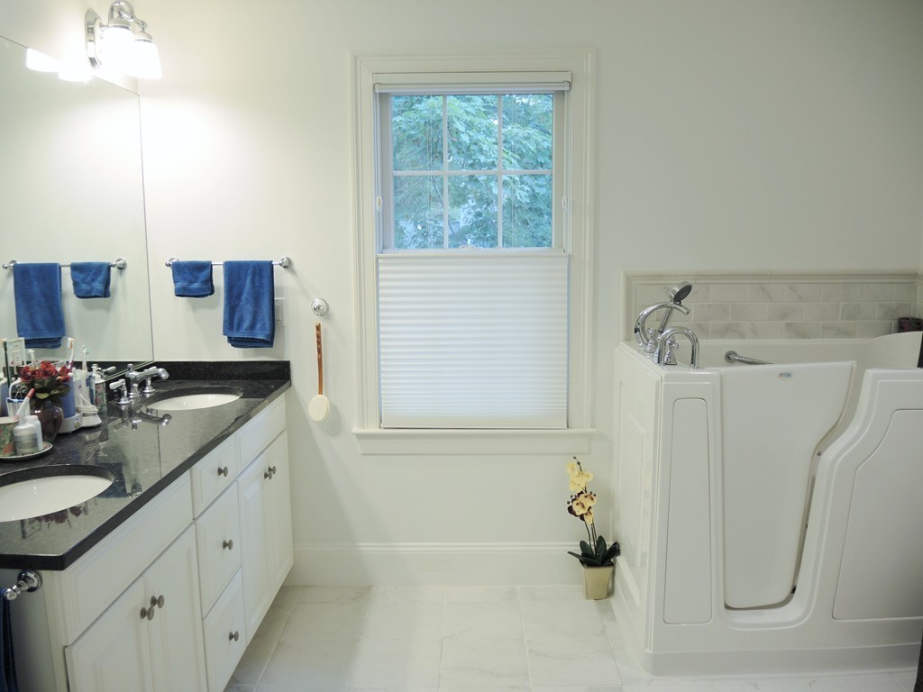 38 Maple Street, Unit 2 Needham, MA 02492 - Photo 21 of 26 a bathroom with a double vanity sink and mirror