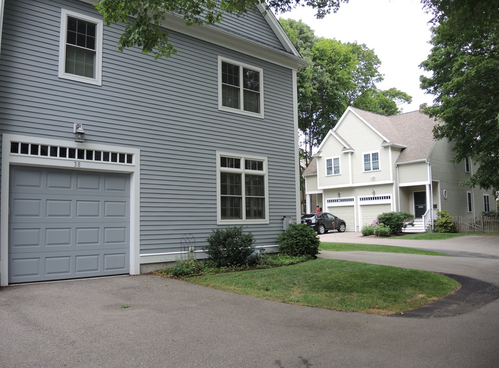 38 Maple Street, Unit 2 Needham, MA 02492 - Photo 26 of 26 a front view of a house with a yard and garage