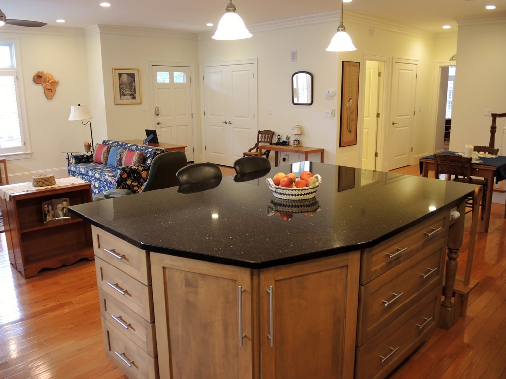 38 Maple Street, Unit 2 Needham, MA 02492 - Photo 5 of 26 a kitchen with kitchen island granite countertop a sink and cabinets