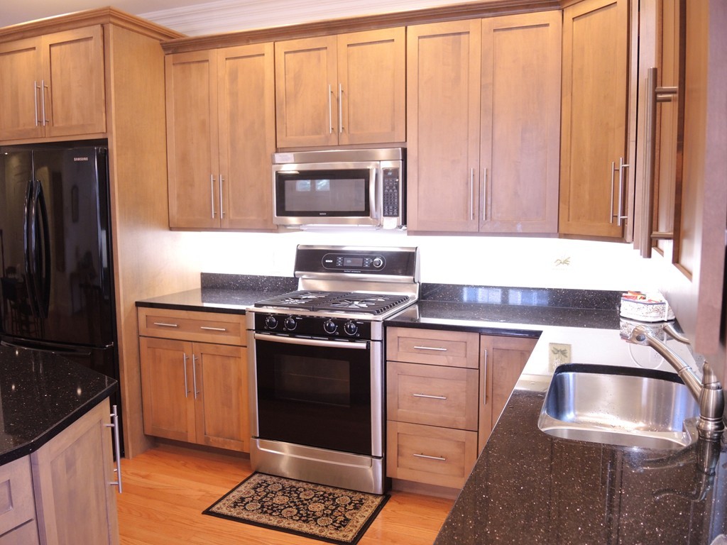38 Maple Street, Unit 2 Needham, MA 02492 - Photo 8 of 26 a kitchen with granite countertop a stove sink and refrigerator