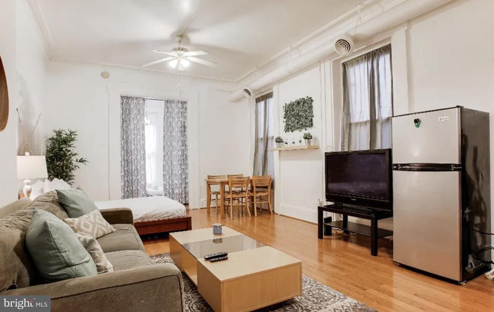 1837 Chestnut Street Philadelphia, PA 19103 - Photo 2 of 7 a living room with furniture a flat screen tv and a window