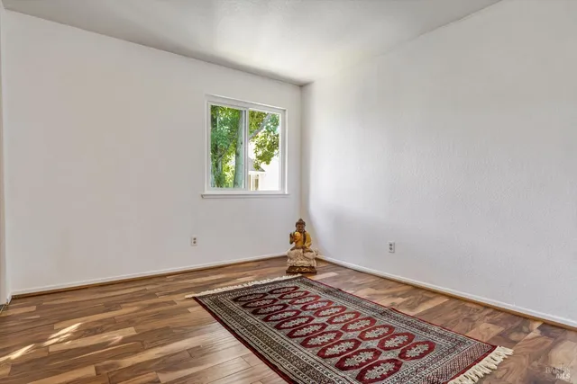 an empty room with wooden floor and window