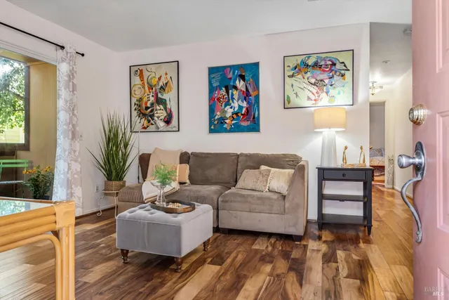 a living room with furniture and a painting on the wall
