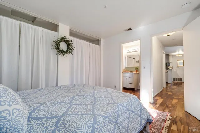 a spacious bedroom with a bed and a mirror