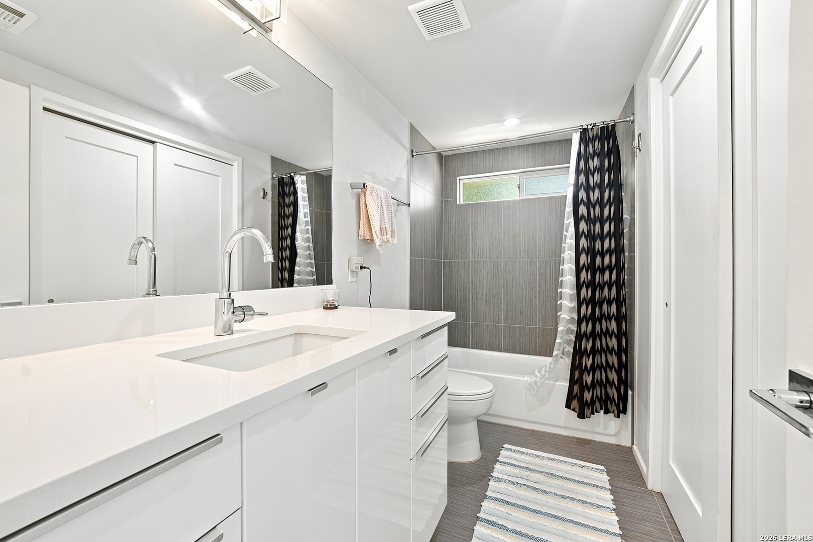 4610 Tanney Street Austin, TX 78721 - Photo 16 of 27 a bathroom with a sink a toilet a mirror and shower