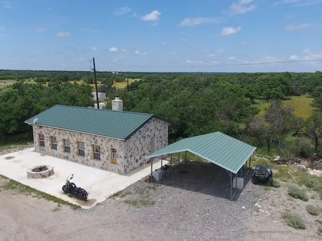 an aerial view of a house with yard and parking