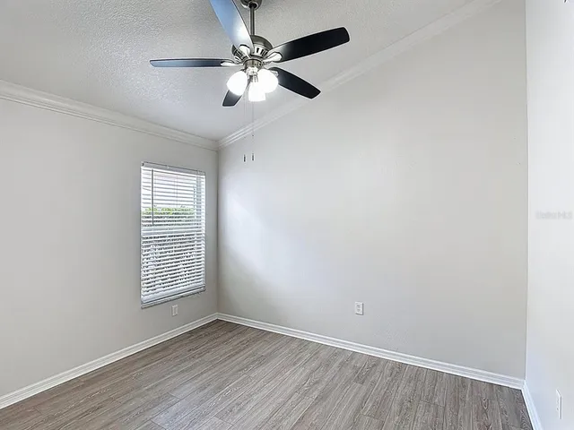 an empty room with windows and fan