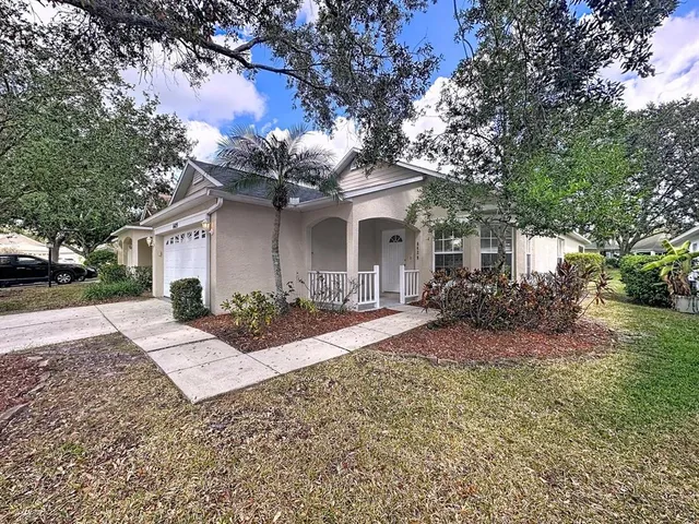 a view of a house with backyard and a tree