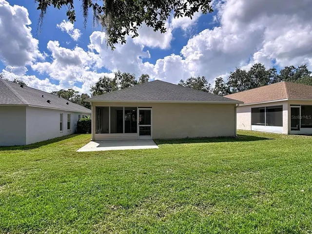 a backyard of a house with yard table and chairs