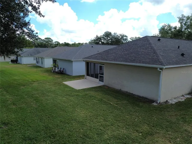 a view of a yard in front of a house with a large tree