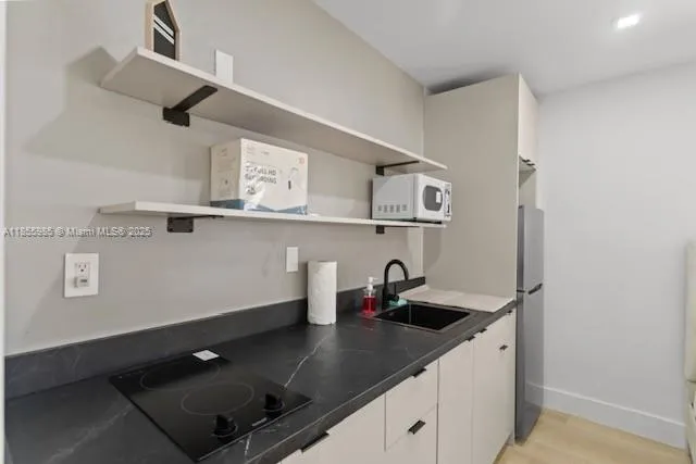 a kitchen with a sink a stove and cabinets