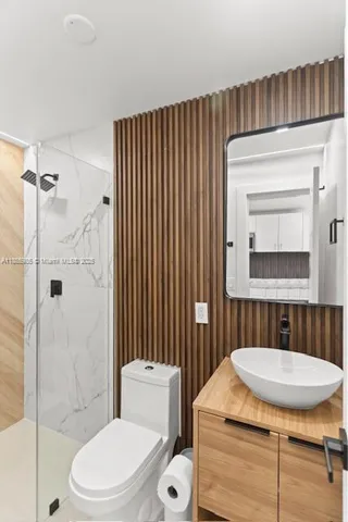 a bathroom with a sink toilet a mirror and shower