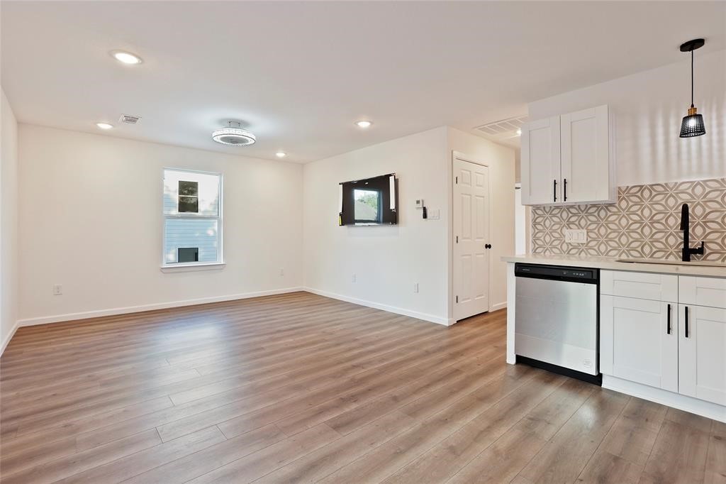310 Delmar Street, Unit C Houston, TX 77011 - Photo 5 of 11 a kitchen with wooden floors and white cabinets