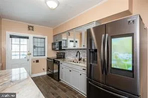 a kitchen with stainless steel appliances granite countertop a refrigerator and a stove
