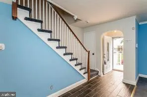 a view of staircase with wooden floor and white walls