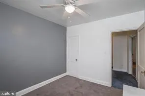 an empty room with a ceiling fan and a window