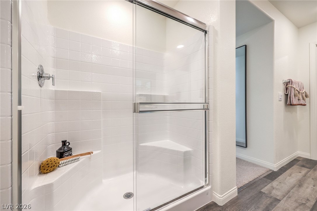 1017 Copper Robin Street Henderson, NV 89011 - Photo 24 of 43 Full bath featuring wood finished floors, a shower stall, and baseboards. Photo is representational only; actual home finishes may vary.