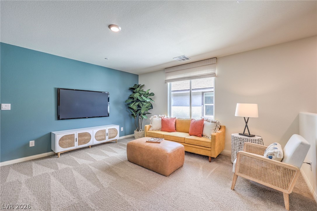 1017 Copper Robin Street Henderson, NV 89011 - Photo 26 of 43 Photo is representational only; actual home finishes may vary. Carpeted living room with baseboards