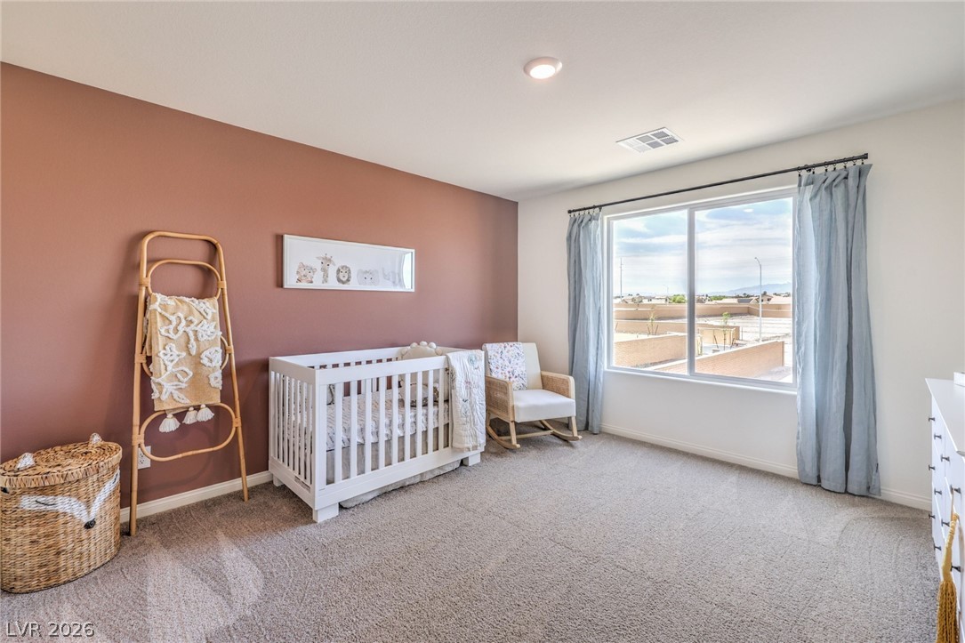 1017 Copper Robin Street Henderson, NV 89011 - Photo 30 of 43 Photo is representational only; actual home finishes may vary. Carpeted bedroom featuring baseboards and a crib