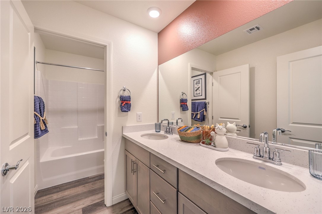1017 Copper Robin Street Henderson, NV 89011 - Photo 34 of 43 Photo is representational only; actual home finishes may vary. Full bathroom with wood finished floors, double vanity, and shower / washtub combination