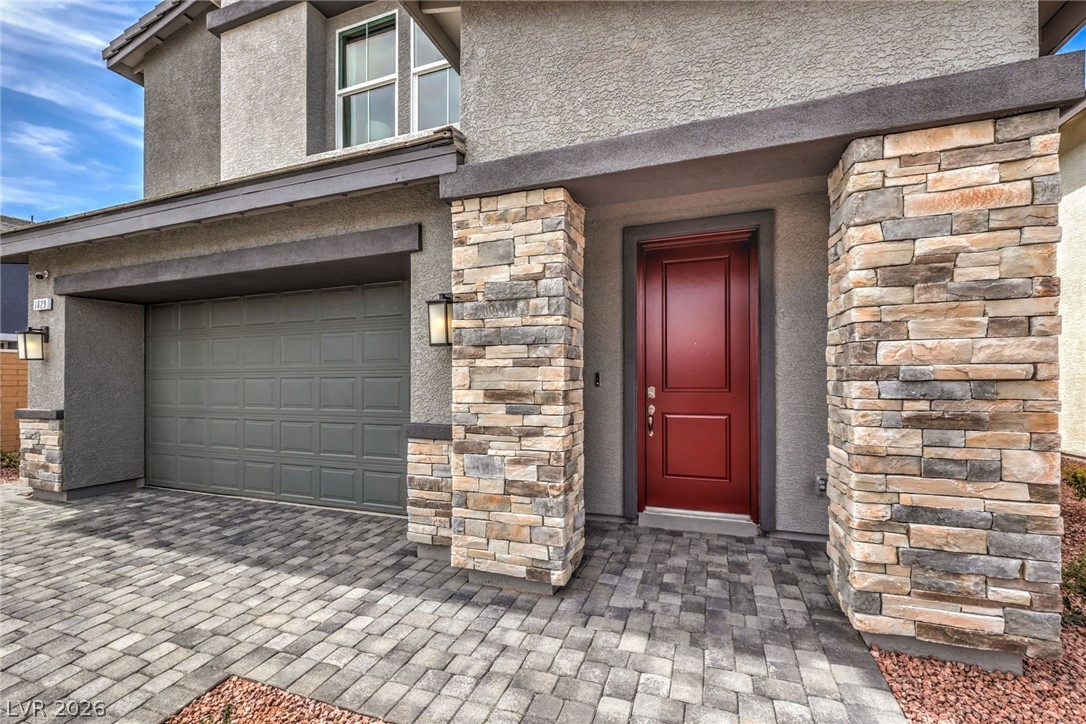 1017 Copper Robin Street Henderson, NV 89011 - Photo 4 of 43 Entrance to property featuring stucco siding, a garage, and stone siding