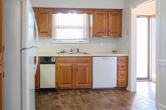 a view of a kitchen with wooden floor and cabinets