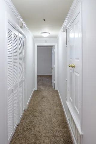 a view of a hallway with wooden floor and closet