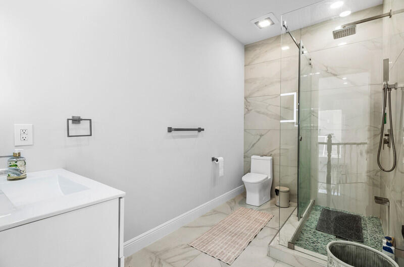 7748 Travelers Tree Drive Boca Raton, FL 33433 - Photo 16 of 31 a bathroom with a granite countertop a toilet and a shower