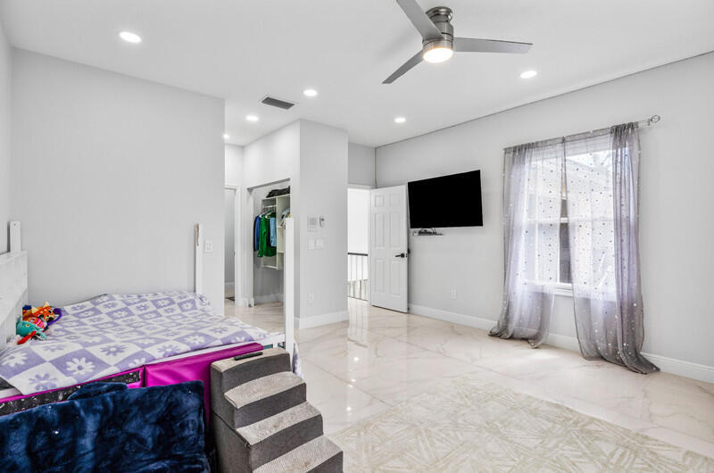 7748 Travelers Tree Drive Boca Raton, FL 33433 - Photo 21 of 31 a bedroom with furniture and flat screen tv