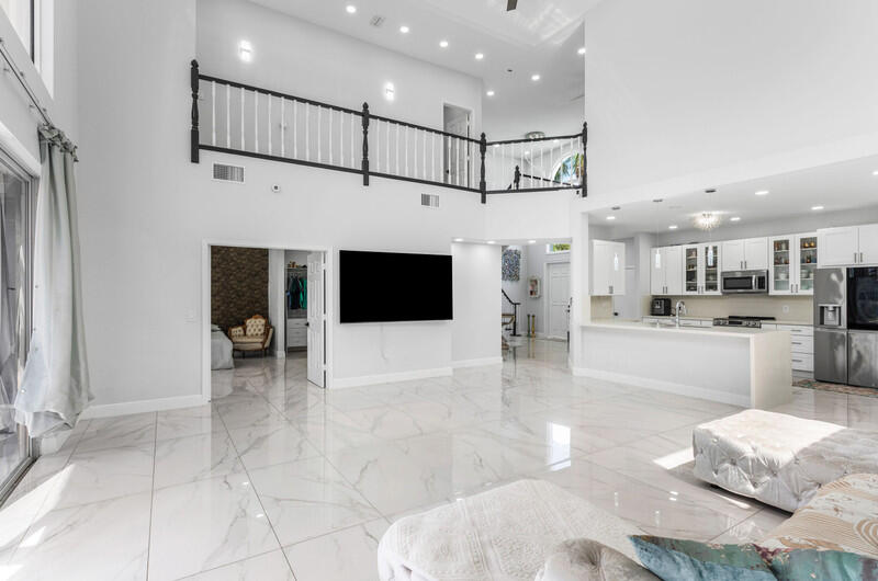 7748 Travelers Tree Drive Boca Raton, FL 33433 - Photo 6 of 31 a large white kitchen with stainless steel appliances kitchen island granite countertop a refrigerator and a stove top oven