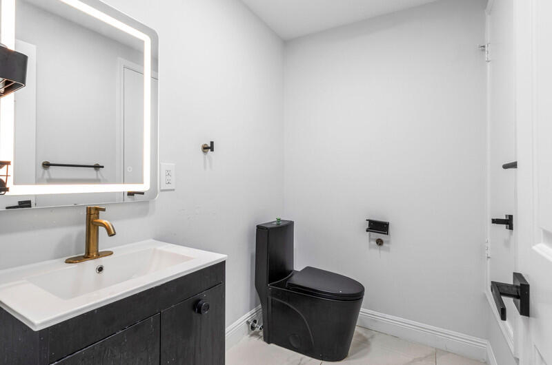 7748 Travelers Tree Drive Boca Raton, FL 33433 - Photo 9 of 31 a bathroom with a sink a toilet and mirror