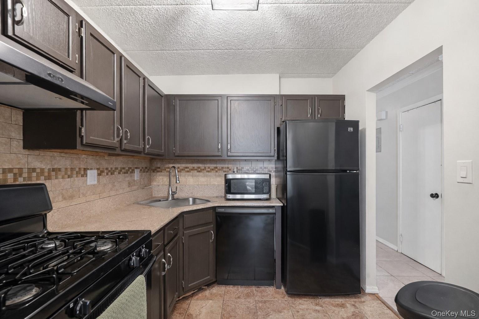 863 Home Street Bronx, NY 10459 - Photo 22 of 46 a kitchen with a refrigerator stove and microwave