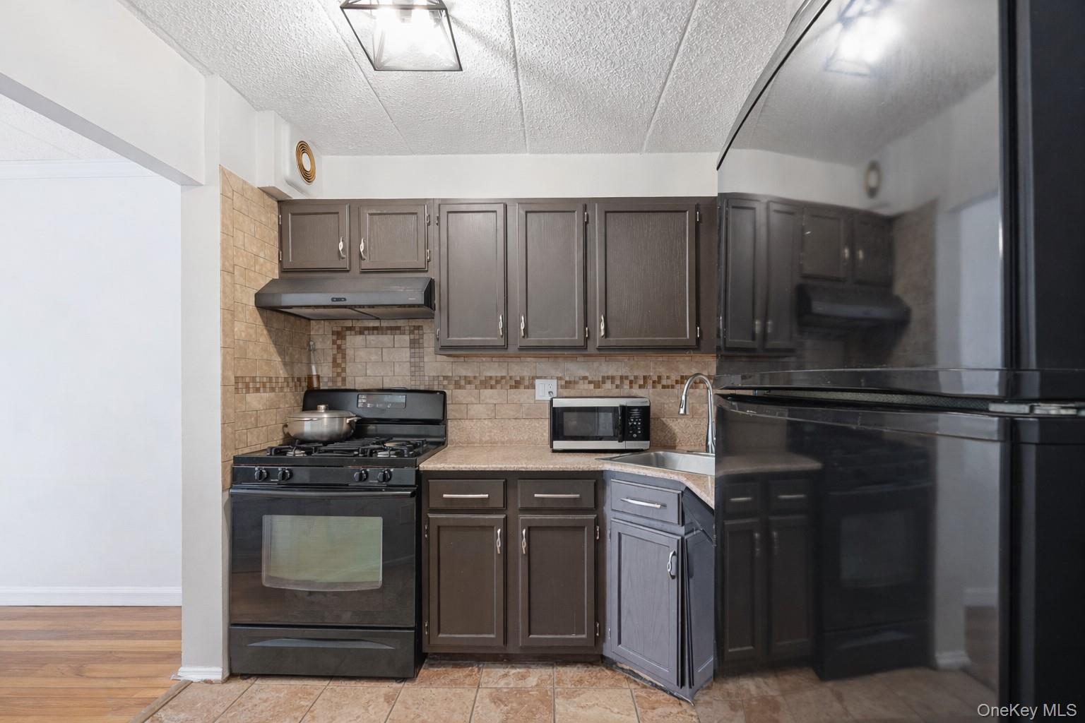 863 Home Street Bronx, NY 10459 - Photo 23 of 46 a kitchen with kitchen island stainless steel appliances a stove refrigerator and cabinets
