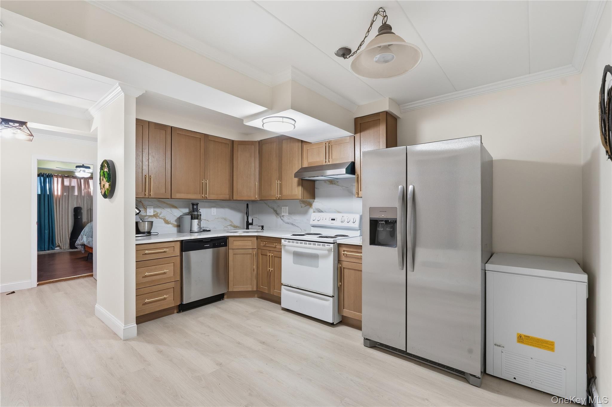 863 Home Street Bronx, NY 10459 - Photo 6 of 46 a kitchen with stainless steel appliances a refrigerator a stove and white cabinets