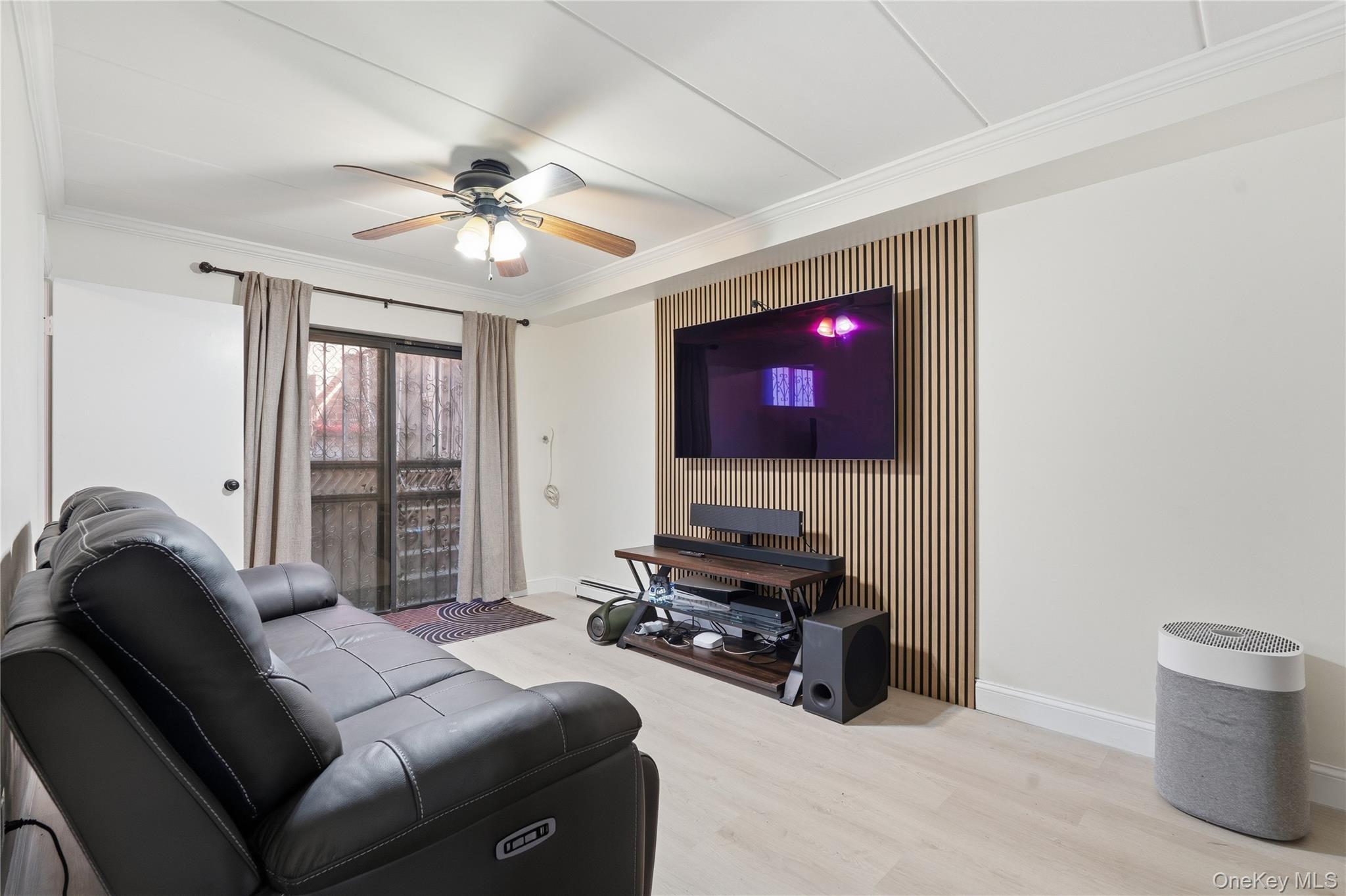 863 Home Street Bronx, NY 10459 - Photo 10 of 46 a living room with furniture a flat screen tv and gym equipment