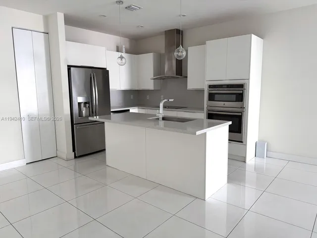 a kitchen with stainless steel appliances a refrigerator sink and microwave