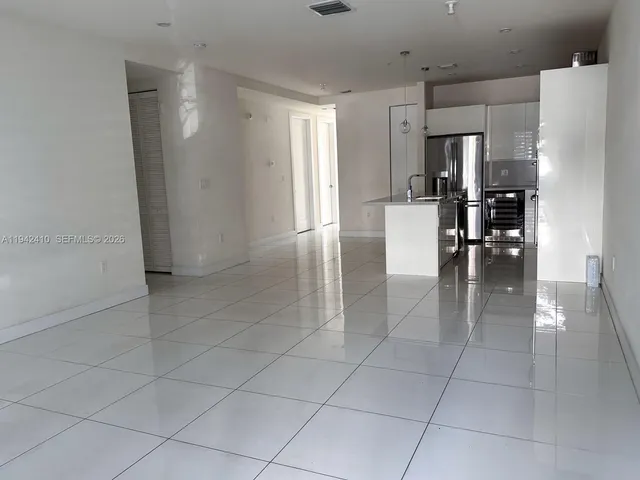 a view of a kitchen with refrigerator and chairs