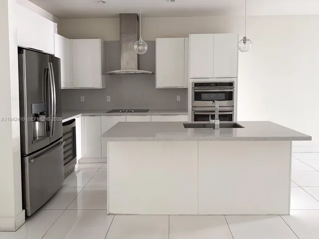 a kitchen with stainless steel appliances and refrigerator