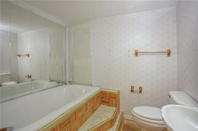 a bathroom with a sink a toilet and a mirror