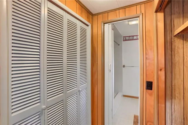 a view of an empty room with closet and a window