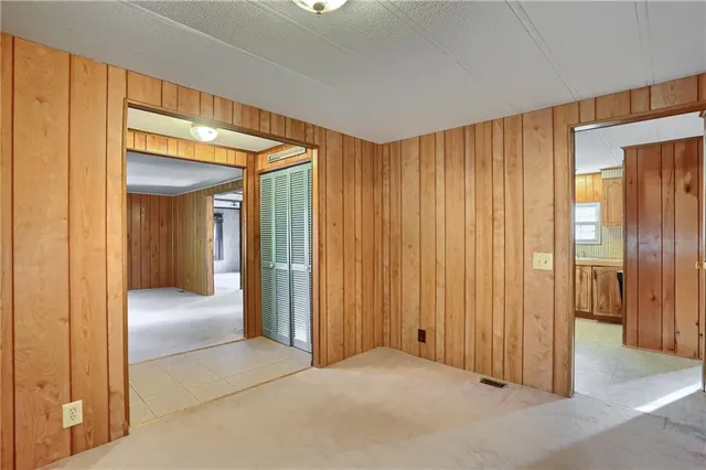 a view of an empty room with window and closet area