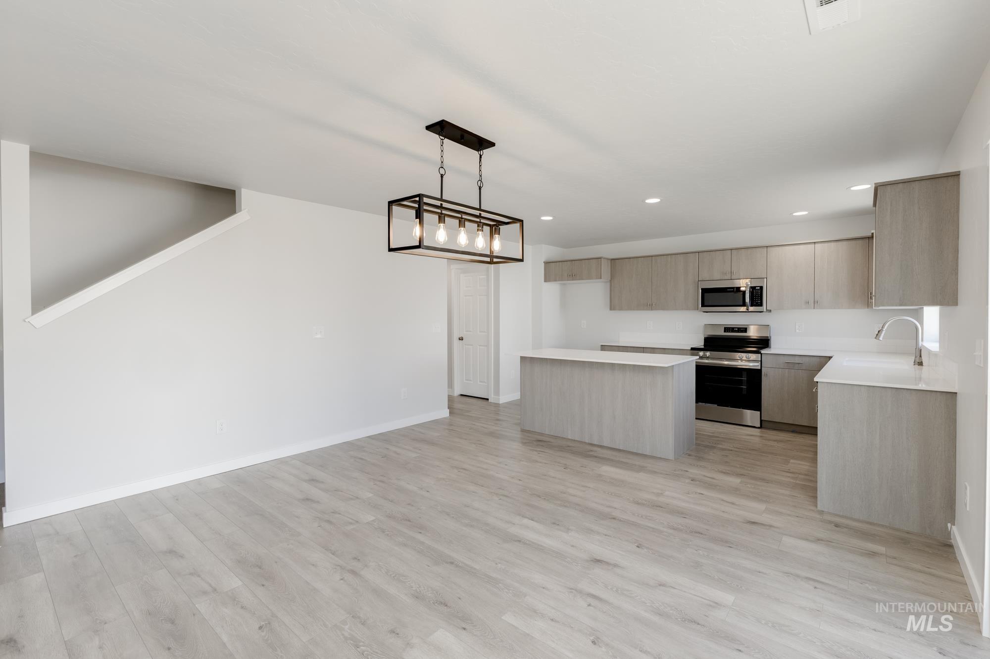 1107 Webb Brk Street Middleton, ID 83644 - Photo 7 of 23 Kitchen featuring stainless steel appliances, modern cabinets, a center island, pendant lighting, and light wood-type flooring